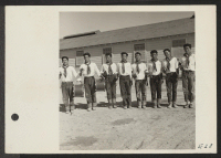 [recto] Members of the drum and bugle corps, formerly a boy scout troop at Los Angeles, pose for their photograph at the Topaz Relocation Center. ;  Photographer: Parker, Tom ;  Topaz, Utah.