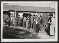 [recto] Group of Hawaiian transferees at Topaz waiting for bus to convey them to Delta Station. ;  Topaz, Utah.