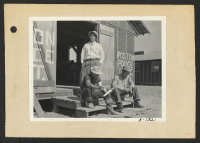 [recto] Poston, Ariz.--Members of the police department carving clubs at this War Relocation Authority center for evacuees of Japanese ancestry. (L to R) standing: Chief Kiyoshi Shigekawa; Toshio Ikeda and Hitoshi Nitta. ;  Photographer: Clark, Fred ;  Poston