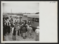 [recto] Buses loaded with passengers for trip 15 to Tule Lake are shown about to leave the assembly center at Topaz. A crowd of friends and relatives wait to bid the passengers farewell. ;  Photographer: Mace, Charles E. ;  Topaz, Utah.
