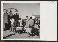 [recto] New arrivals at Heart Mountain from the Tule Lake Center are loaded aboard trucks to be conveyed to their newly assigned quarters. ;  Photographer: Mace, Charles E. ; , .