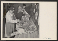 [recto] Sam Takeda and George Yoshihara, former west coast butchers, cutting meat for center mess halls. With meat rationing strictly adhered ...