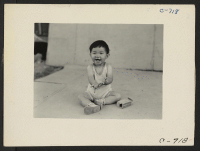 [recto] Manzanar, Calif.--Little evacuee of Japanese ancestry in a happy mood at this War Relocation Authority center. ;  Photographer: Lange, Dorothea ;  Manzanar, California.