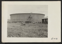 [recto] A view showing the water storage tank, which is under construction at the Jerome Relocation Center. ;  Photographer: Parker, Tom ;  Denson, Arkansas.