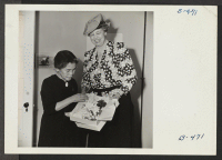 [recto] Mrs. Yamatoto, former P.T.A. president from San Francisco, and now head of the Canal Women's Club, presents Mrs. Eleanor Roosevelt with a bouquet of flowers. ;  Photographer: Stewart, Francis ;  Rivers, Arizona.