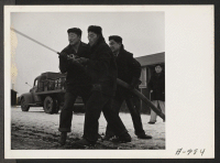 [recto] Evacuee members of the Fire Department brave the cold weather to have a practice drill. ;  Photographer: Stewart, Francis ;  Newell, California.