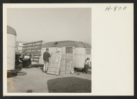 [recto] Family belongs arrive by truck from the relocation center at a temporary trailer home in the Burbank, California, Winona Housing ...