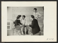 [recto] Drama instructor, Derlan, coaches three drama students in preparing for the presentation of 3 one act plays, as the first presentation of their adult education Little Theatre Group. ;  Photographer: Parker, Tom ;  Amache, Colorado.