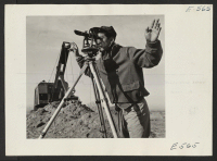 [recto] A young Nisei operates a surveying instrument in laying out the grounds for administrative quarters. ;  Photographer: Parker, Tom ;  Amache, Colorado.