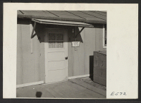 [recto] A typical outside entrance to a barracks apartment. This door leads to a small foyer which opens onto two single room units. ;  Photographer: Parker, Tom ;  Amache, Colorado. 12/11/42 [?]